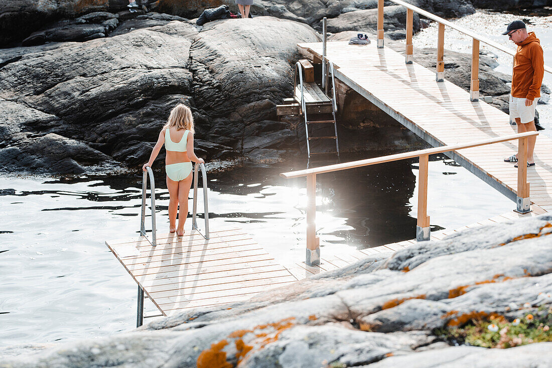 View of girl on jetty at sea