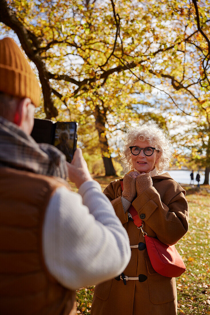 Man photographing woman with cell phone