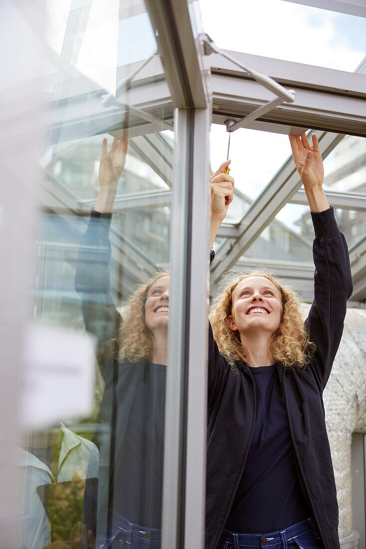 View of woman repairing roof window