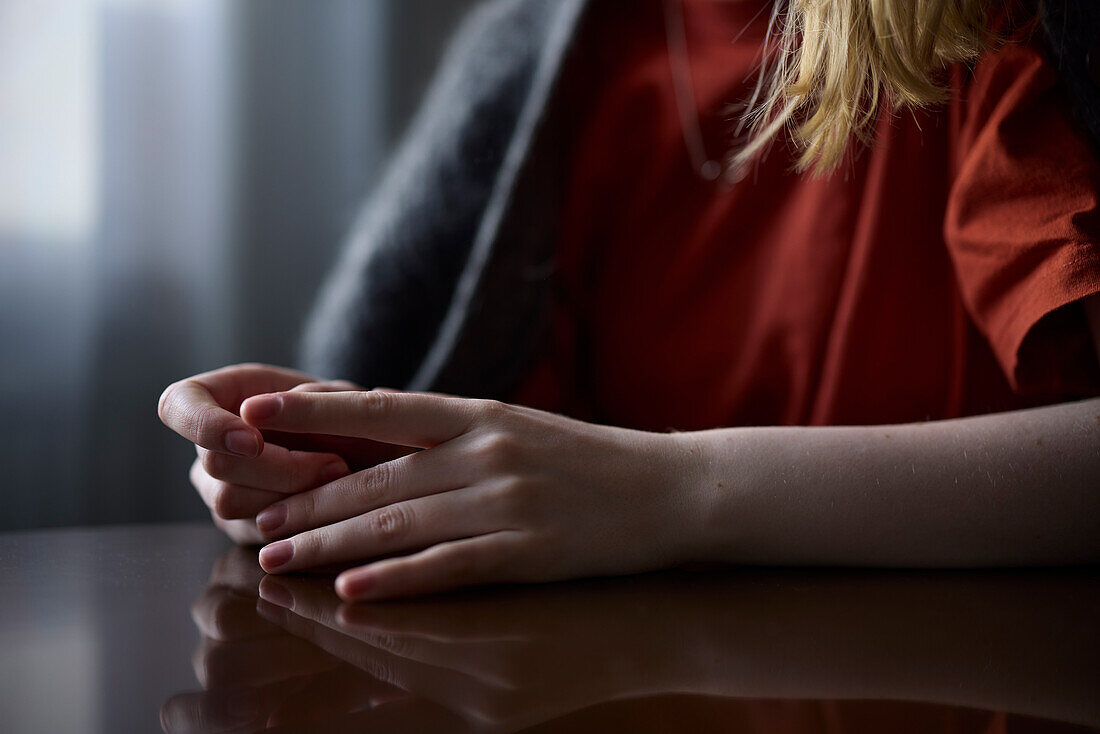 Close-up of teenage girl picking at nails