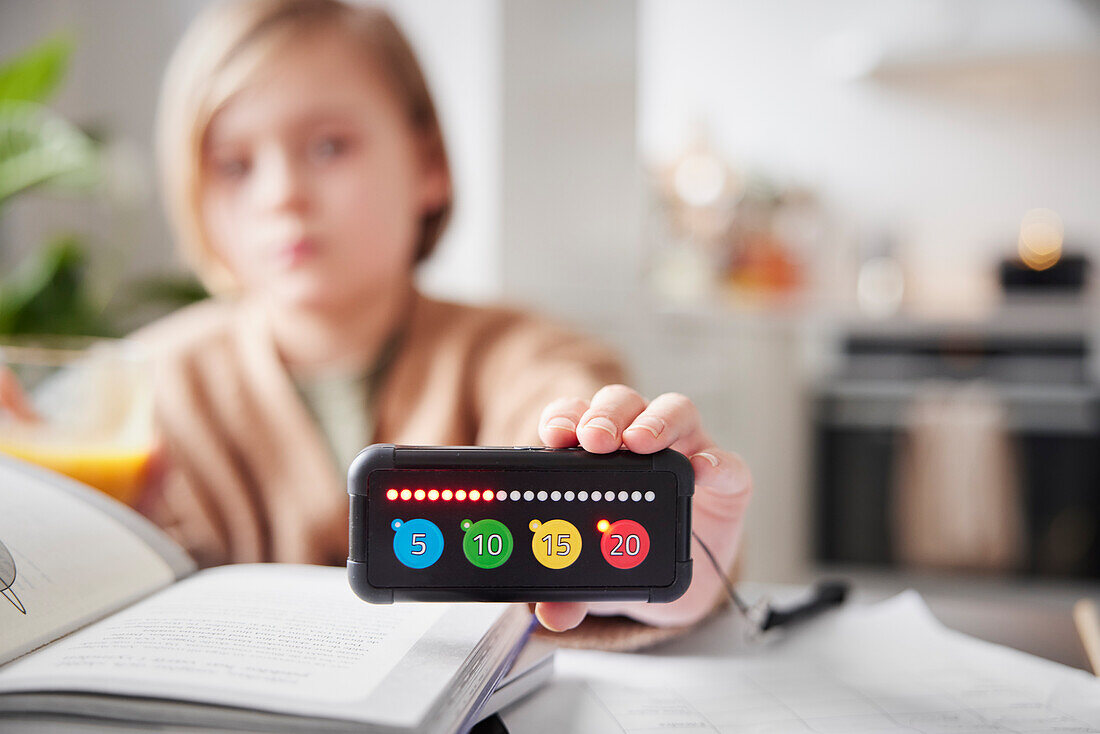 Kind hält elektronisches Lernspiel in der Hand