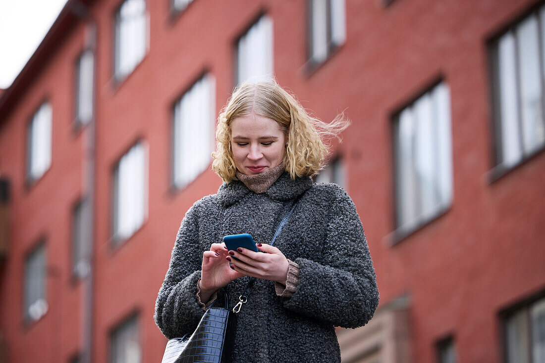 Lächelnde Frau, die ein Handy benutzt