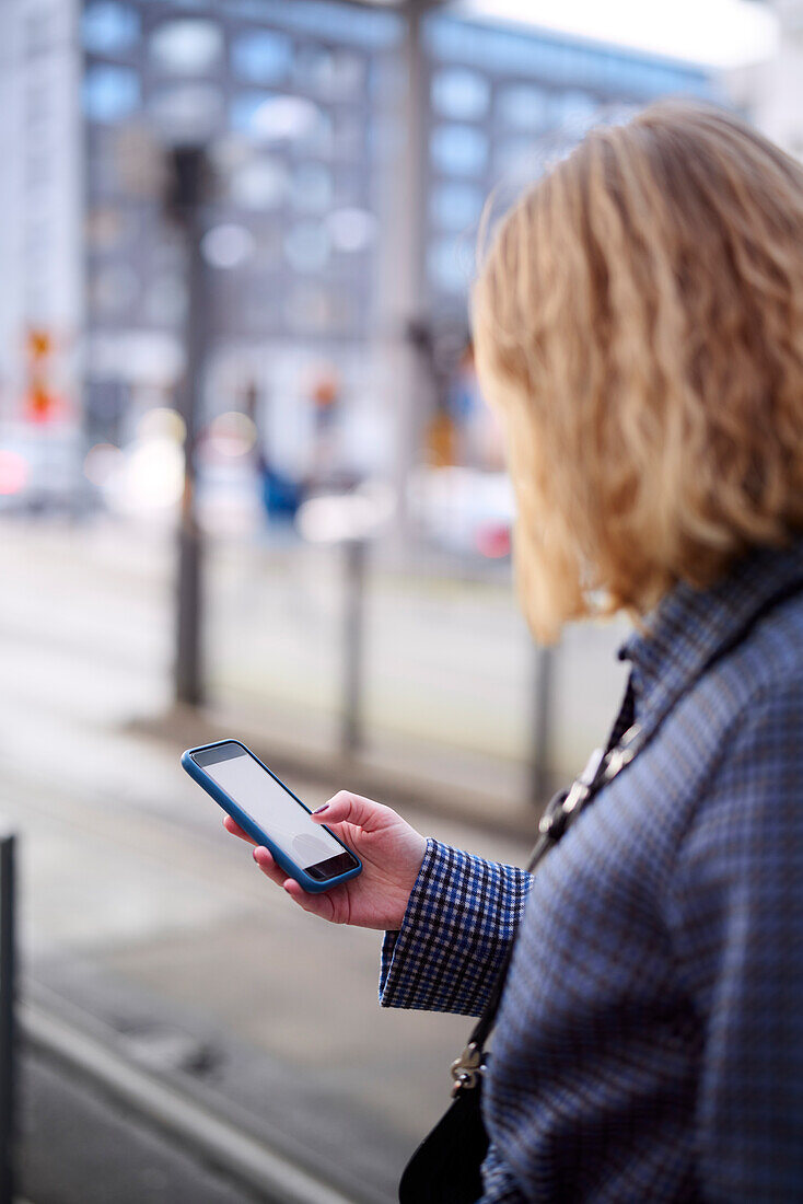 Ansicht einer Frau, die ein Mobiltelefon benutzt