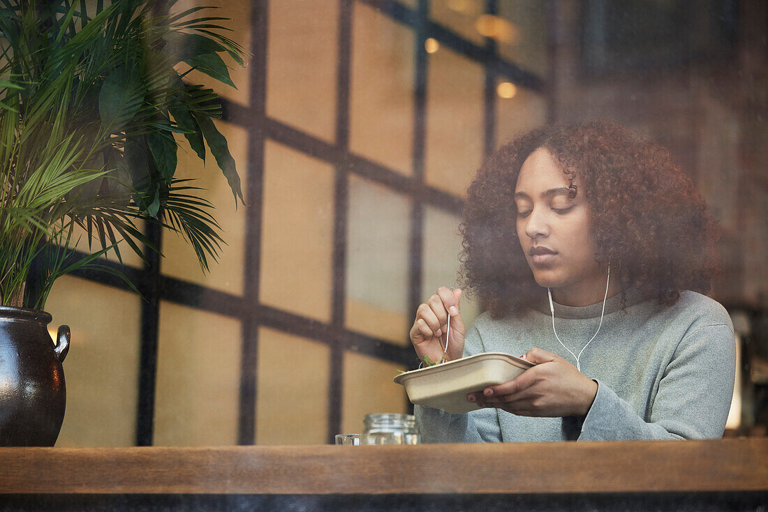 Young woman eating in cafe