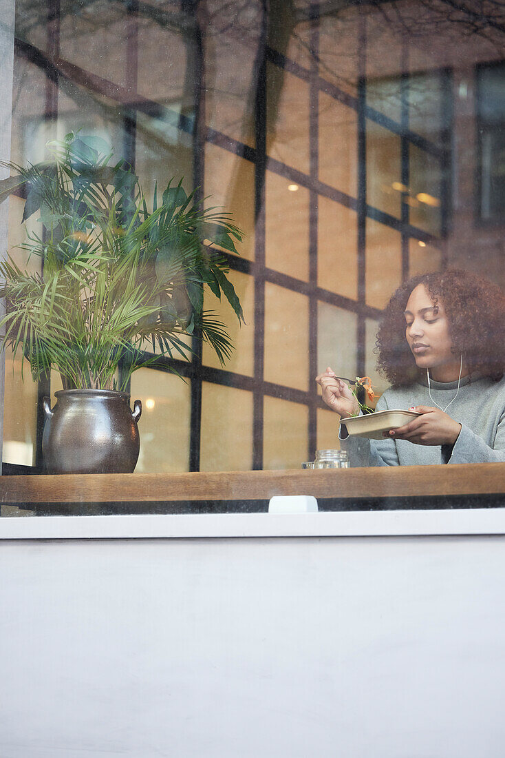 Young woman eating in cafe