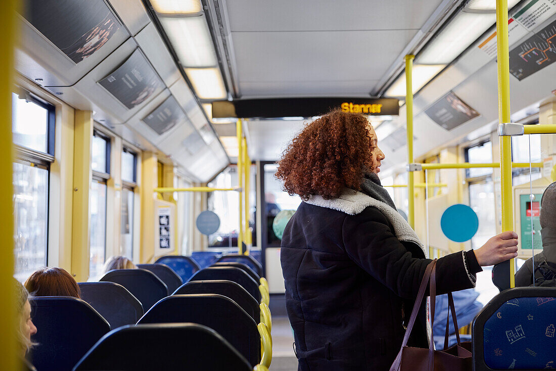 Young woman standing in bus