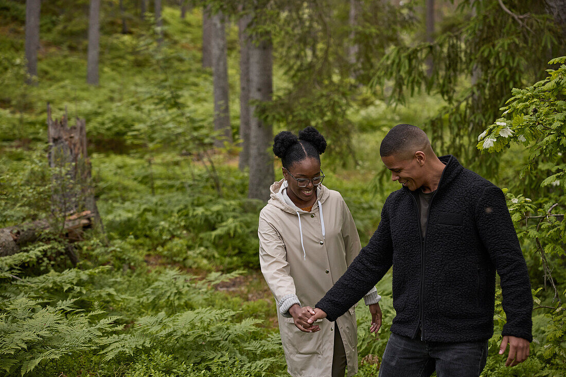 Smiling couple walking through forest