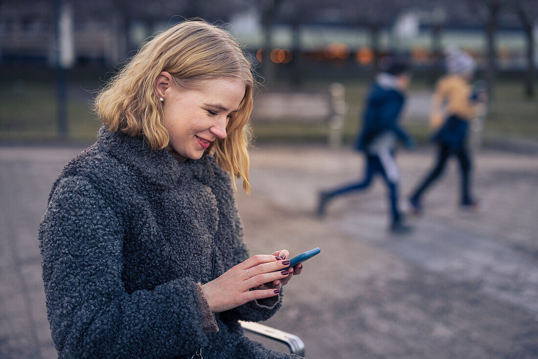 Young woman using phone outdoors