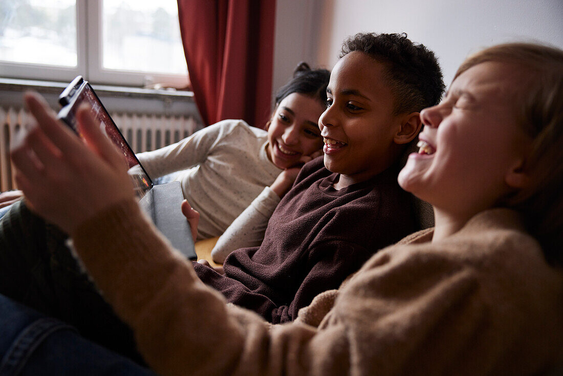 Kinder, die zu Hause ein digitales Tablet benutzen