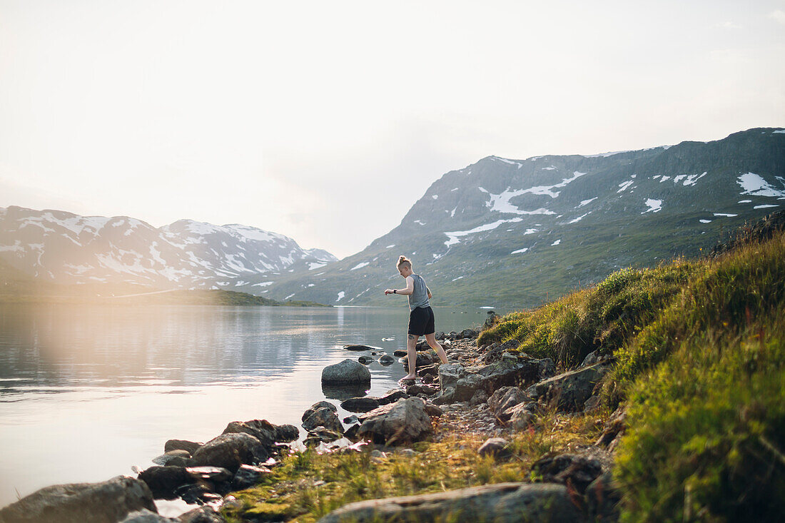 Woman standing at lake in mountains