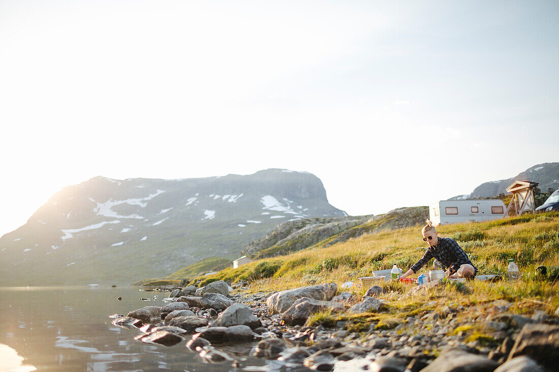 Woman camping, camping site in background