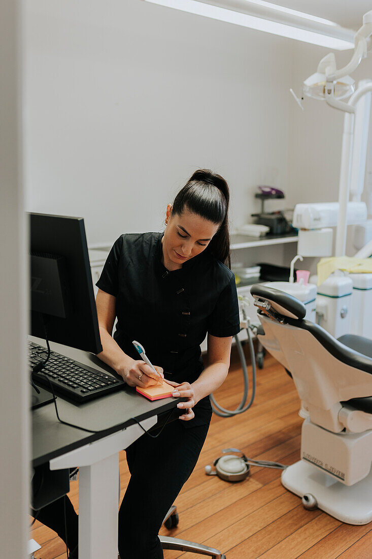 Female dentist using computer in office