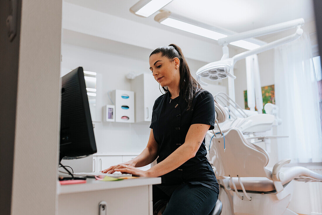 Female dentist using computer in office