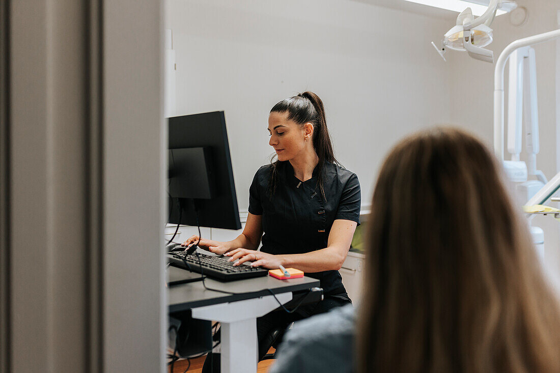 Female dentist using computer in office