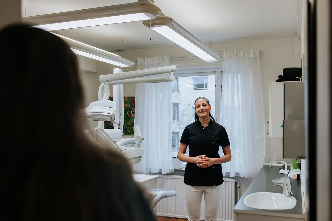 Female dentist standing in office