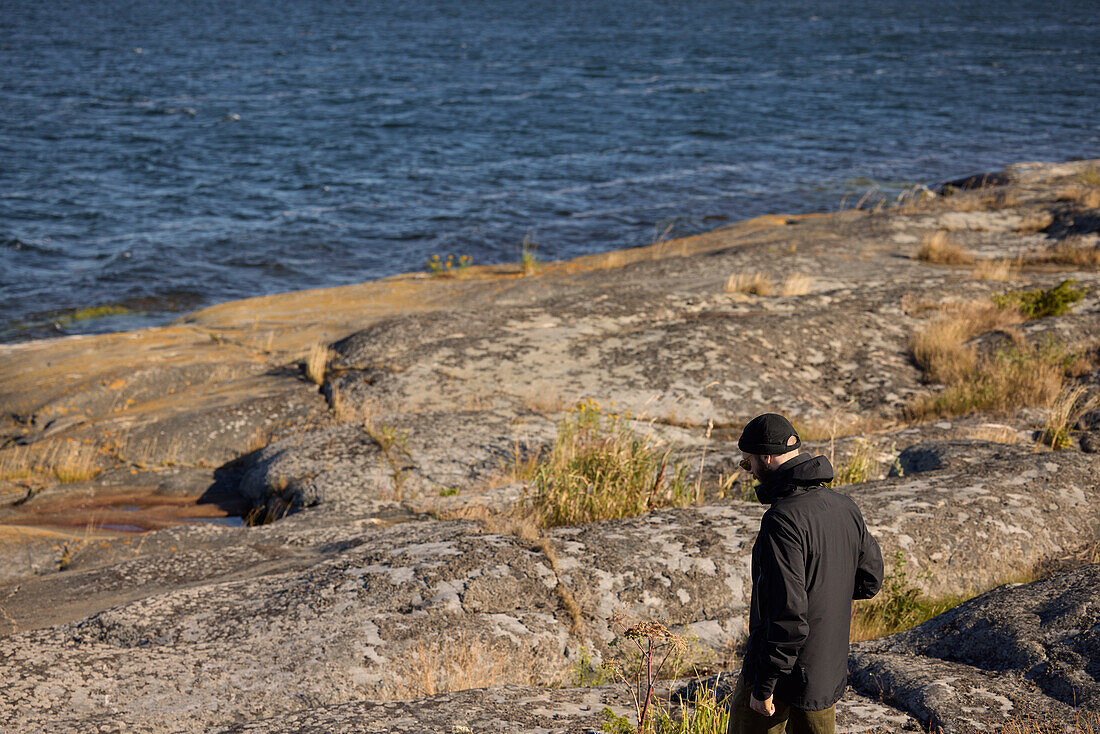 View of man walking at rocky coast