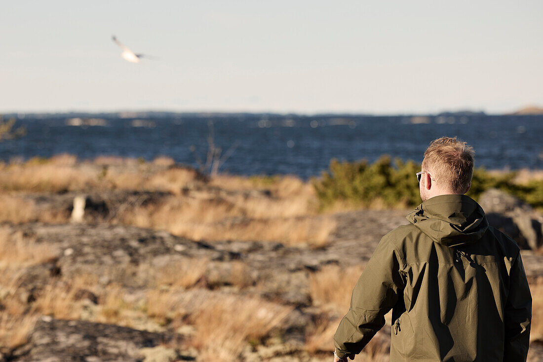 Rear view of man walking at sea