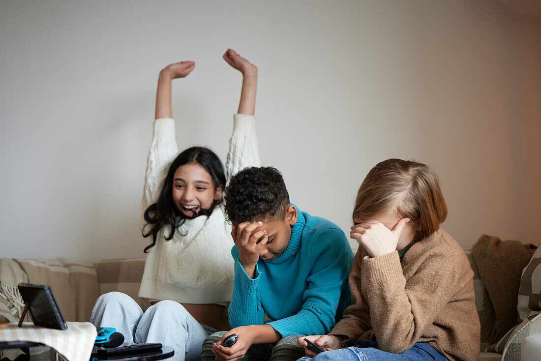 Children playing video games at home and celebrating