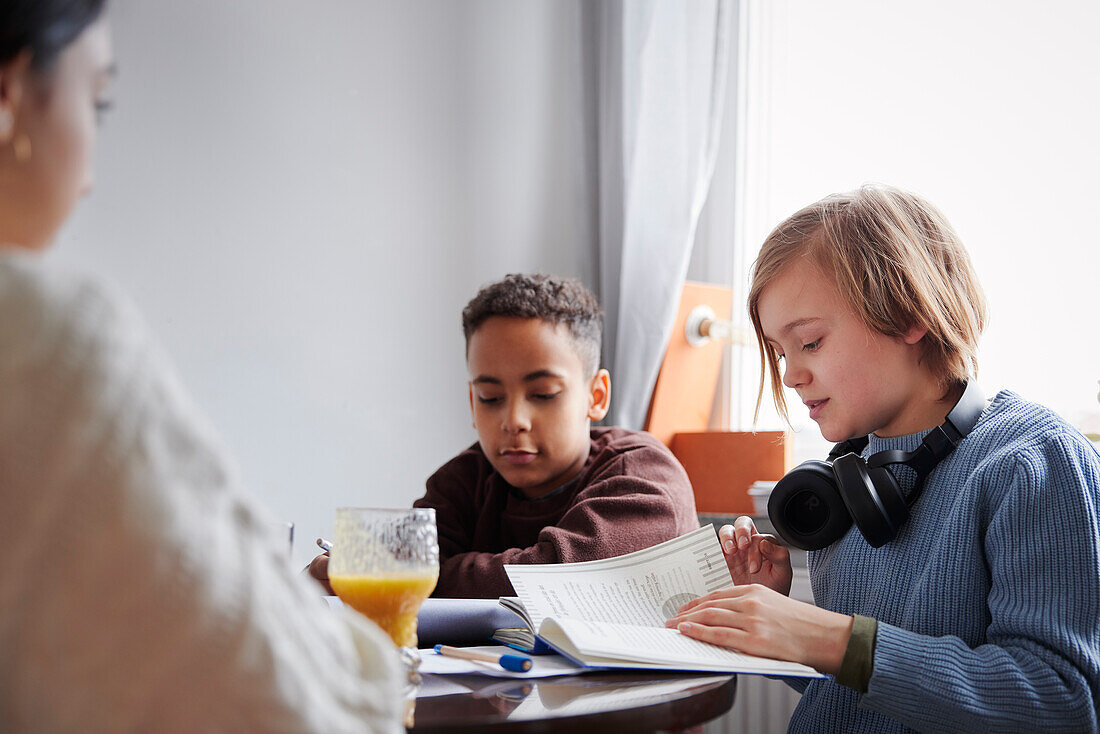 Two boys doing homework at dining table