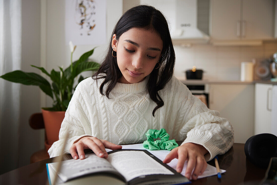 Girl doing homework at dining table