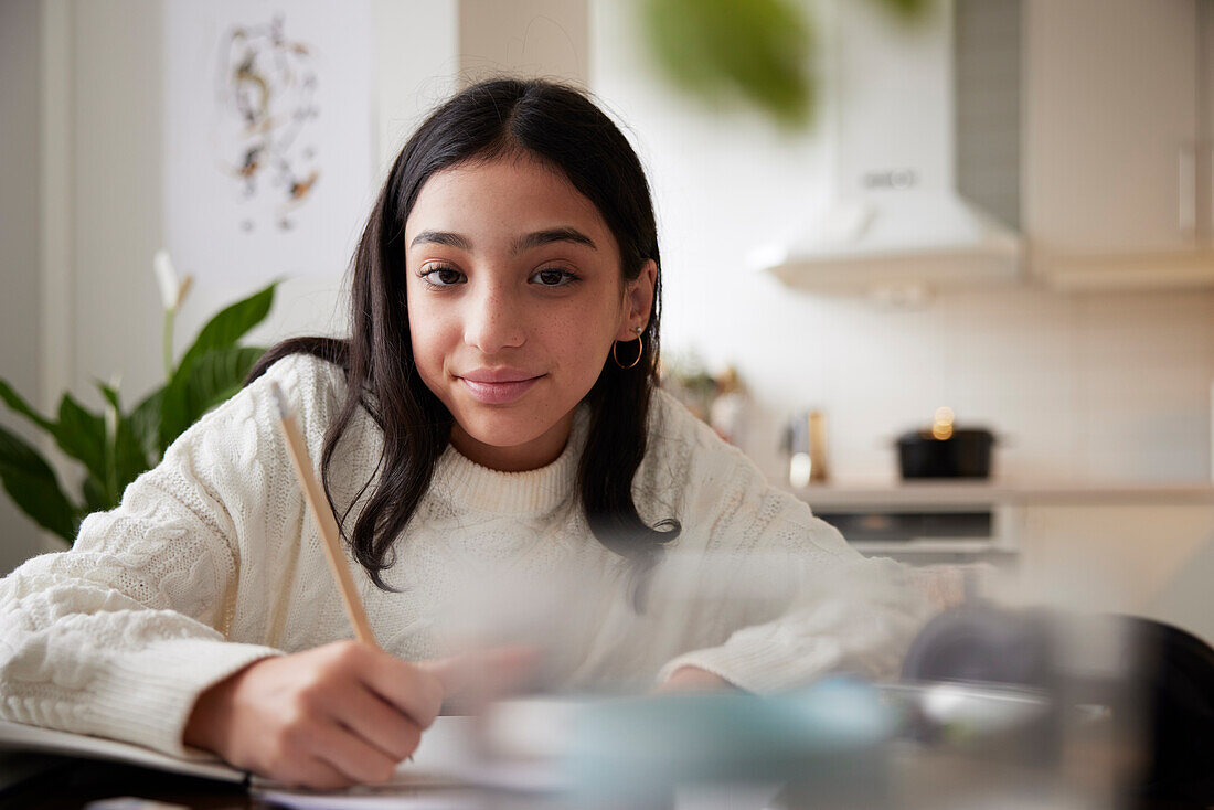 Girl doing homework at dining table