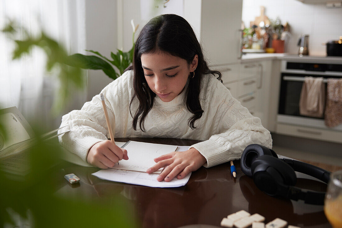 Girl doing homework at dining table