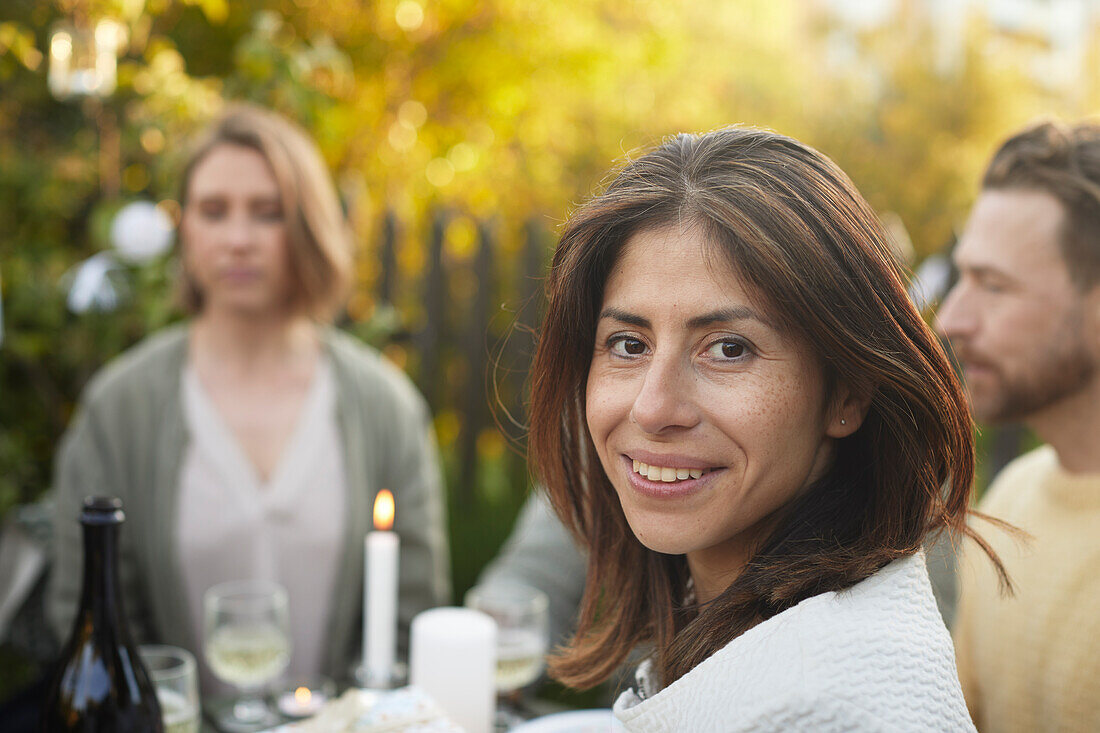 Lächelnde Frau schaut während einer Gartenparty in die Kamera