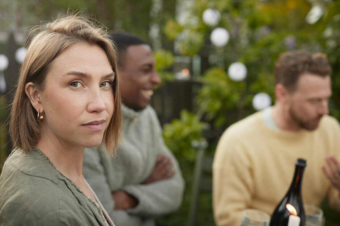 Frau schaut während einer Gartenparty in die Kamera