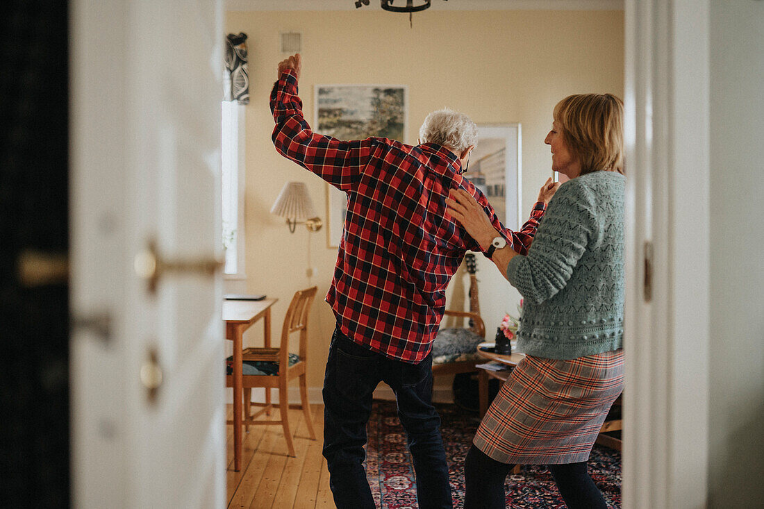 Senior couple dancing at home