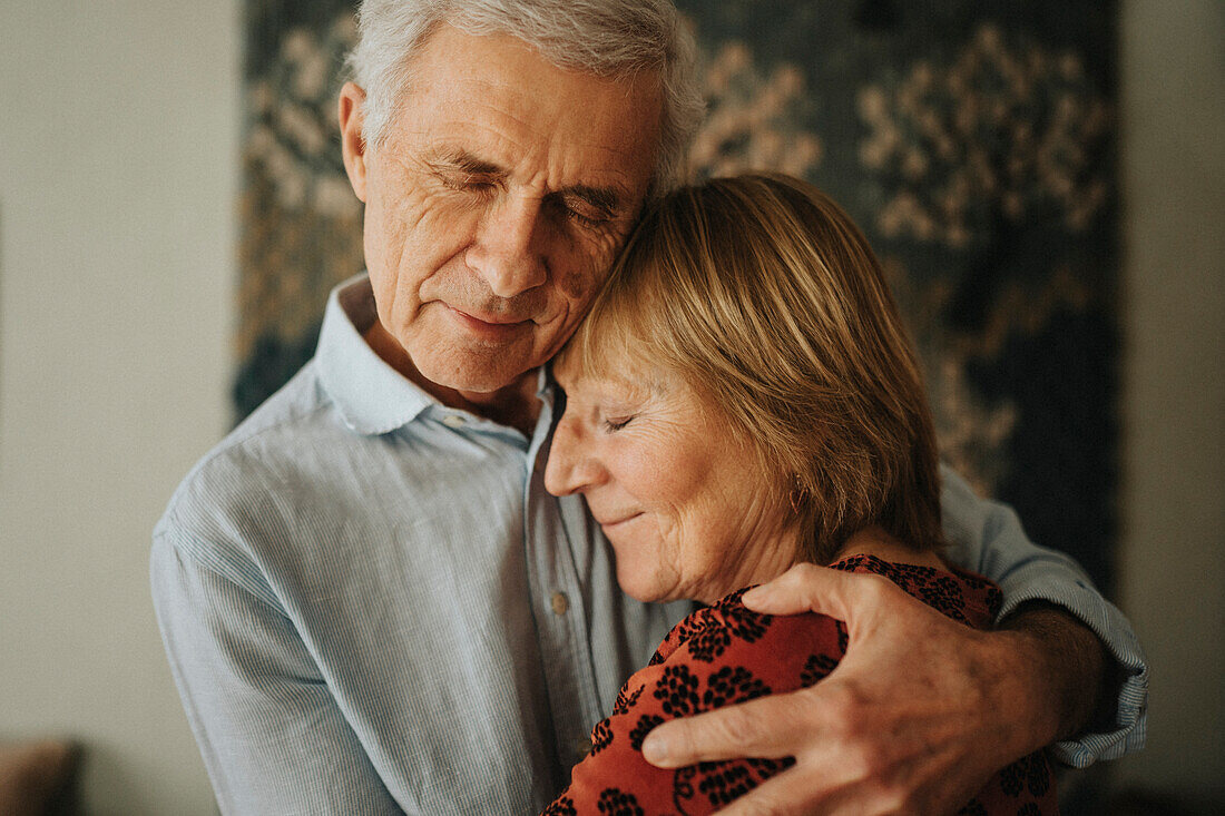 Älteres Paar umarmt sich zu Hause