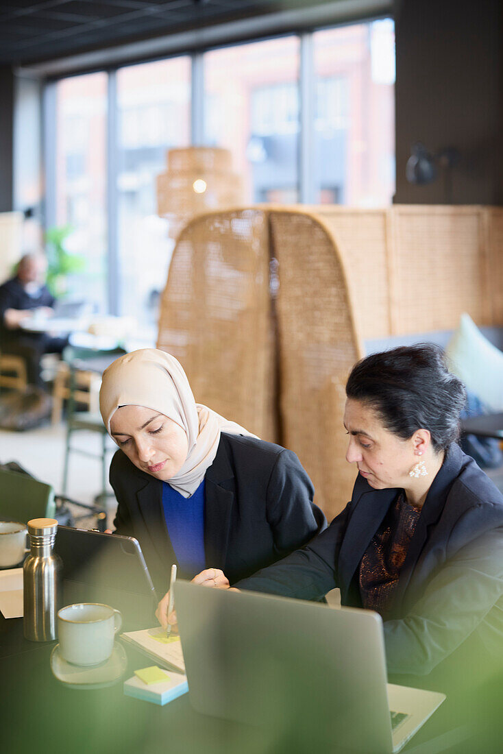 Businesswomen using digital tablet in cafe