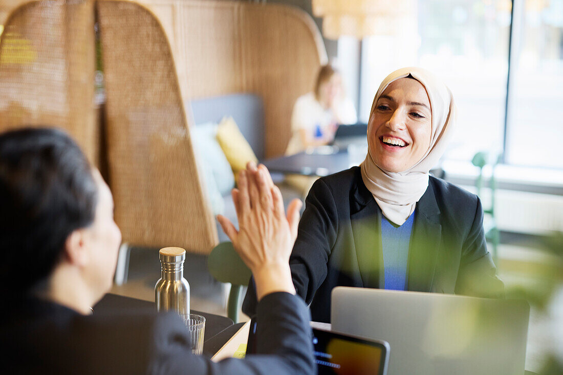 Woman in headscarf sitting in cafe