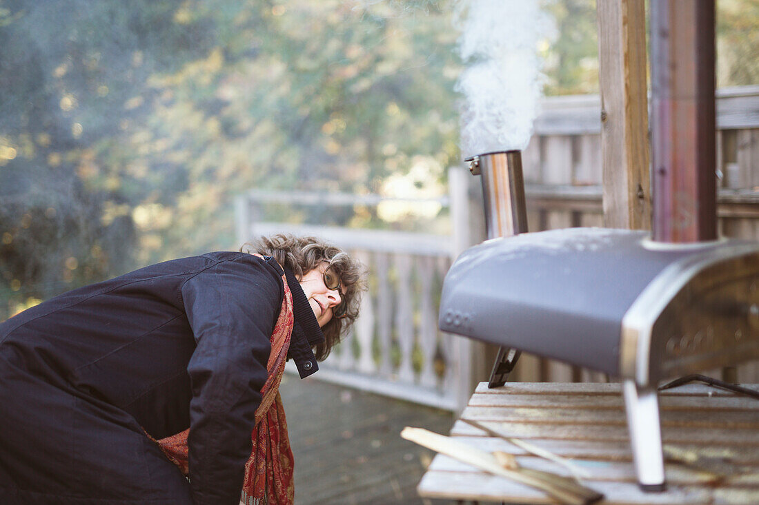 Woman starting fire in outdoor oven