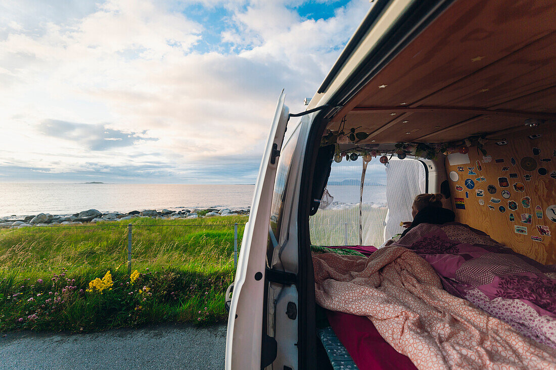 Woman in camper van looking at view
