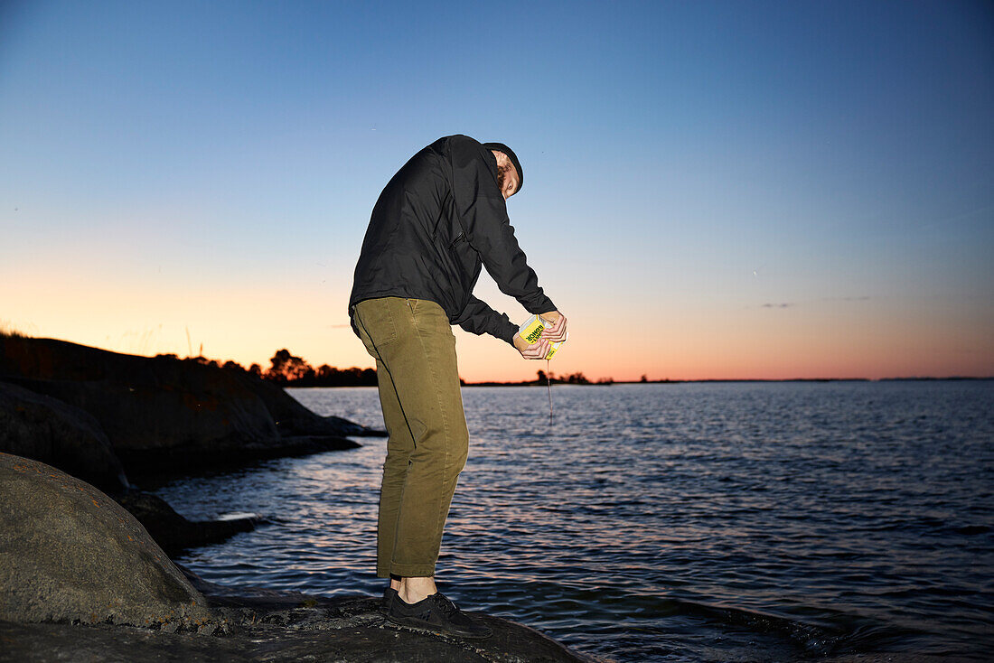 Man standing at sea at sunset