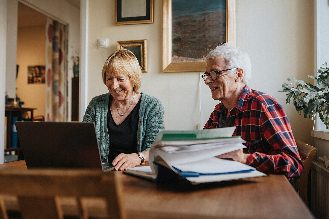 Senior couple using laptop at home