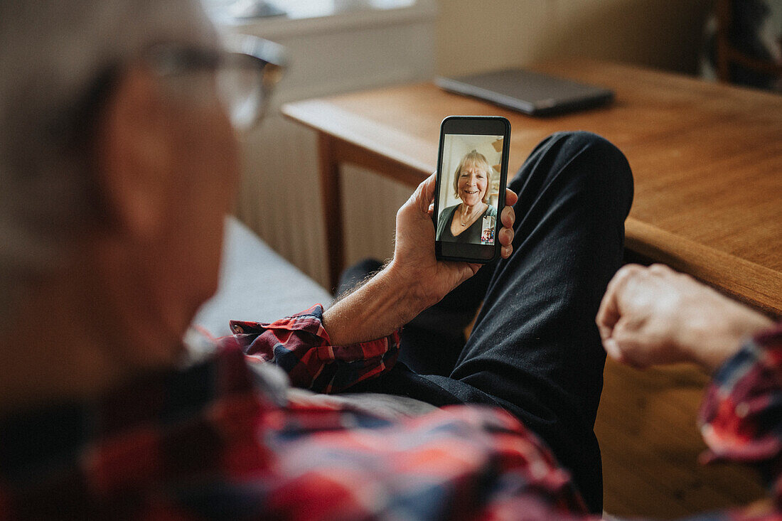 Älterer Mann im Gespräch mit einer Frau per Videoanruf