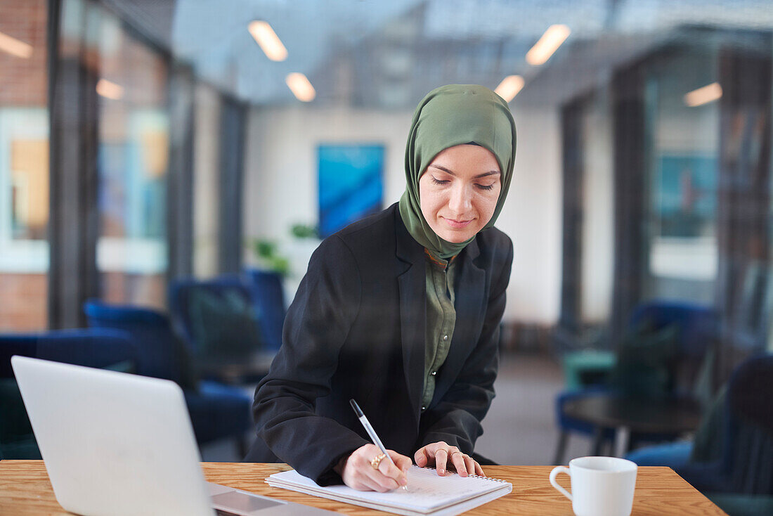 Frau schreibt im Büro