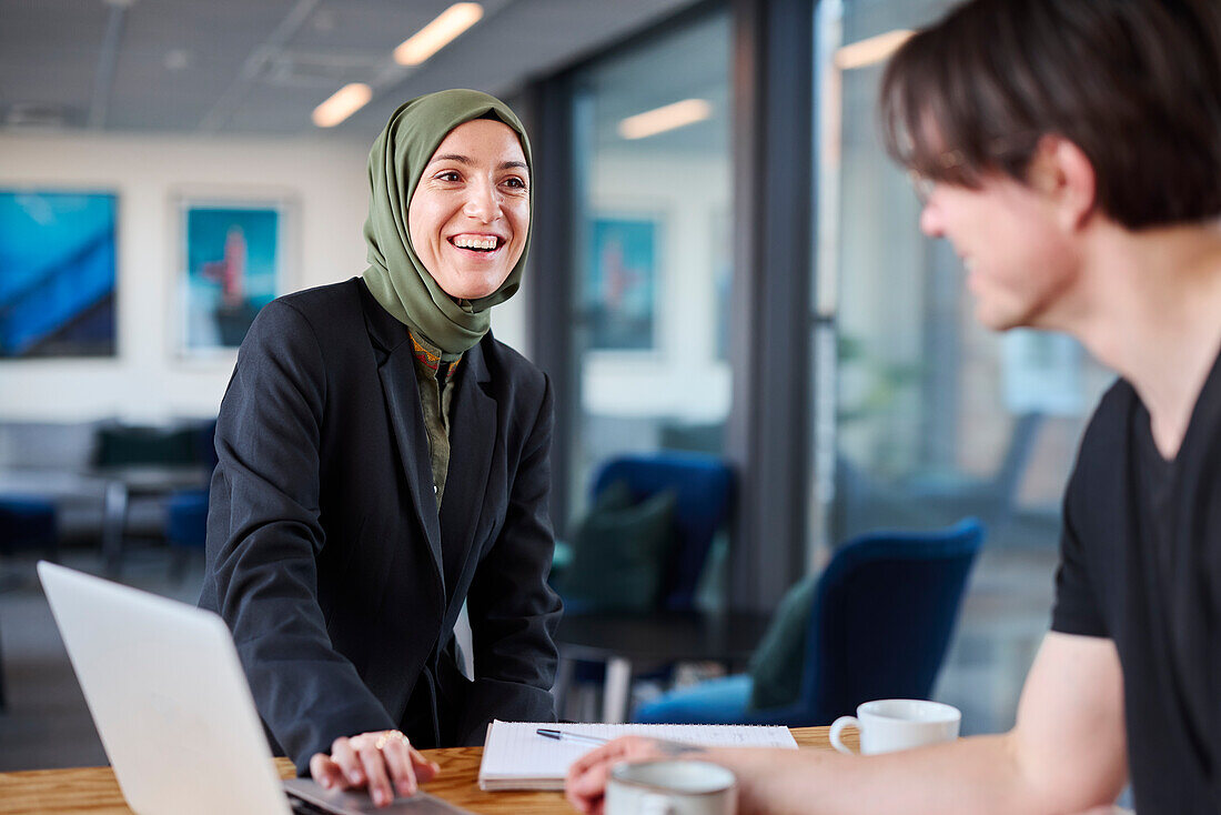 Lächelnde Frau beim Gespräch im Büro