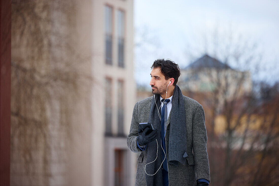 Elegant man with smartphone on street