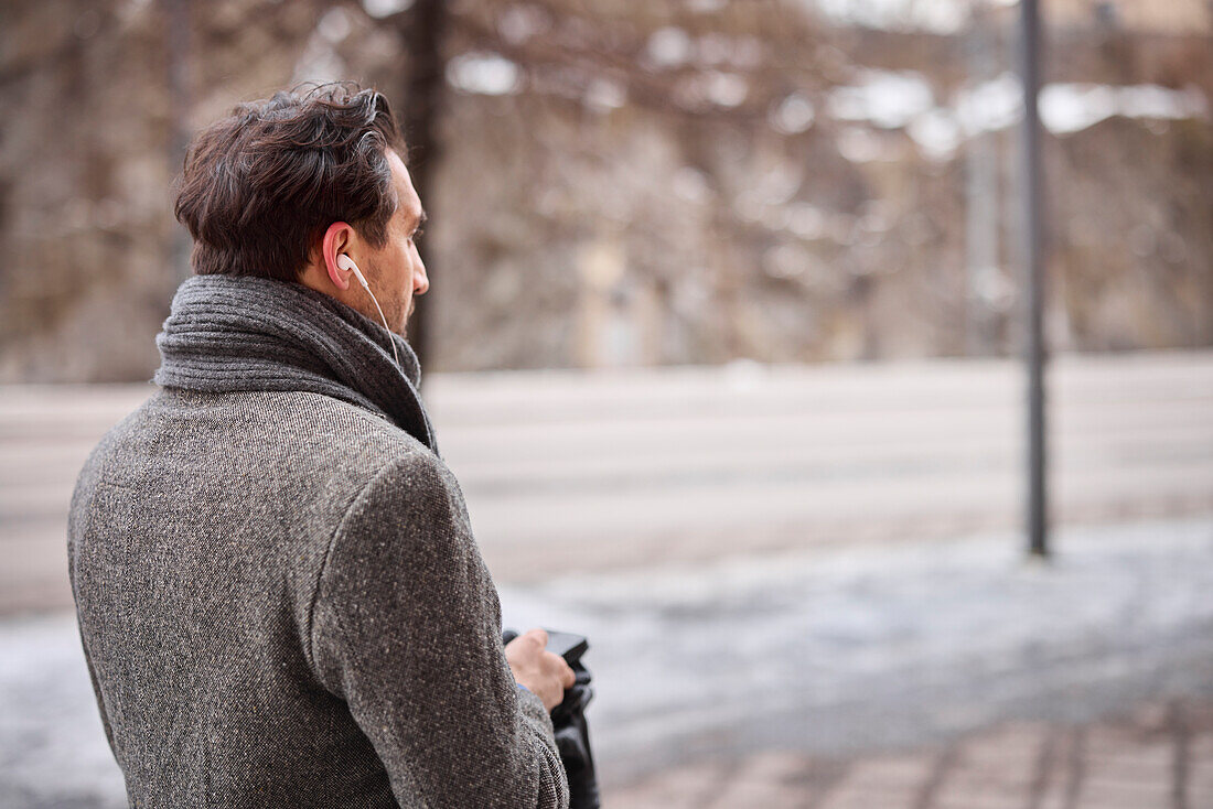 Elegant man with smartphone on street