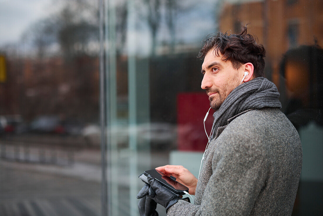 Elegant man with smartphone on street