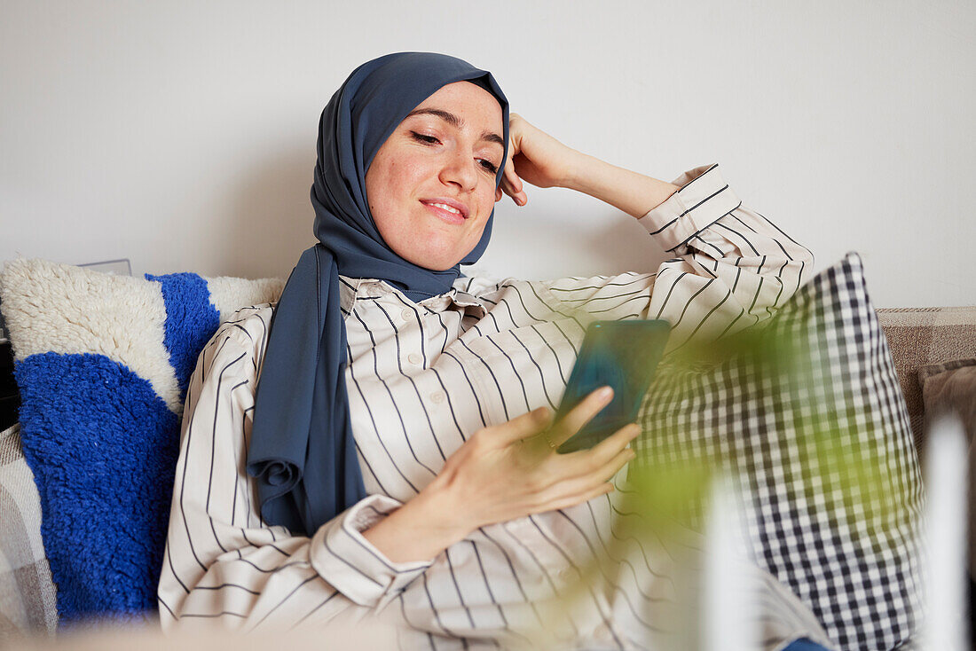 Woman on sofa using cell phone