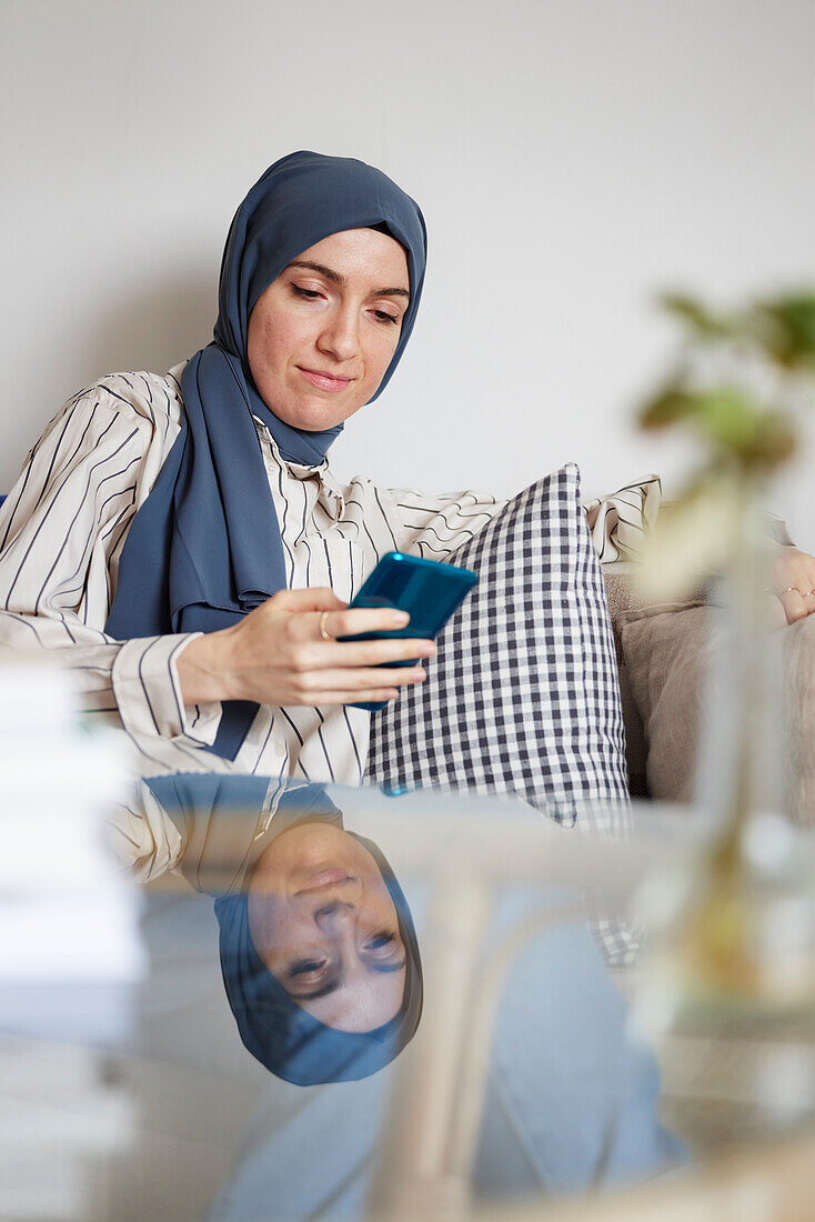 Woman on sofa using cell phone