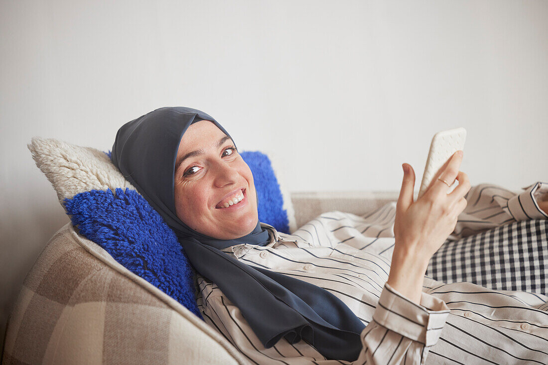 Frau auf dem Sofa schaut in die Kamera