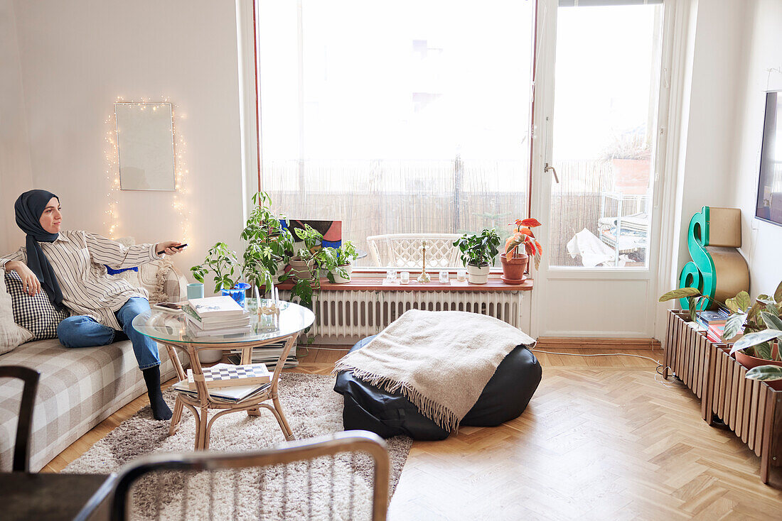 Woman sitting on sofa in living room