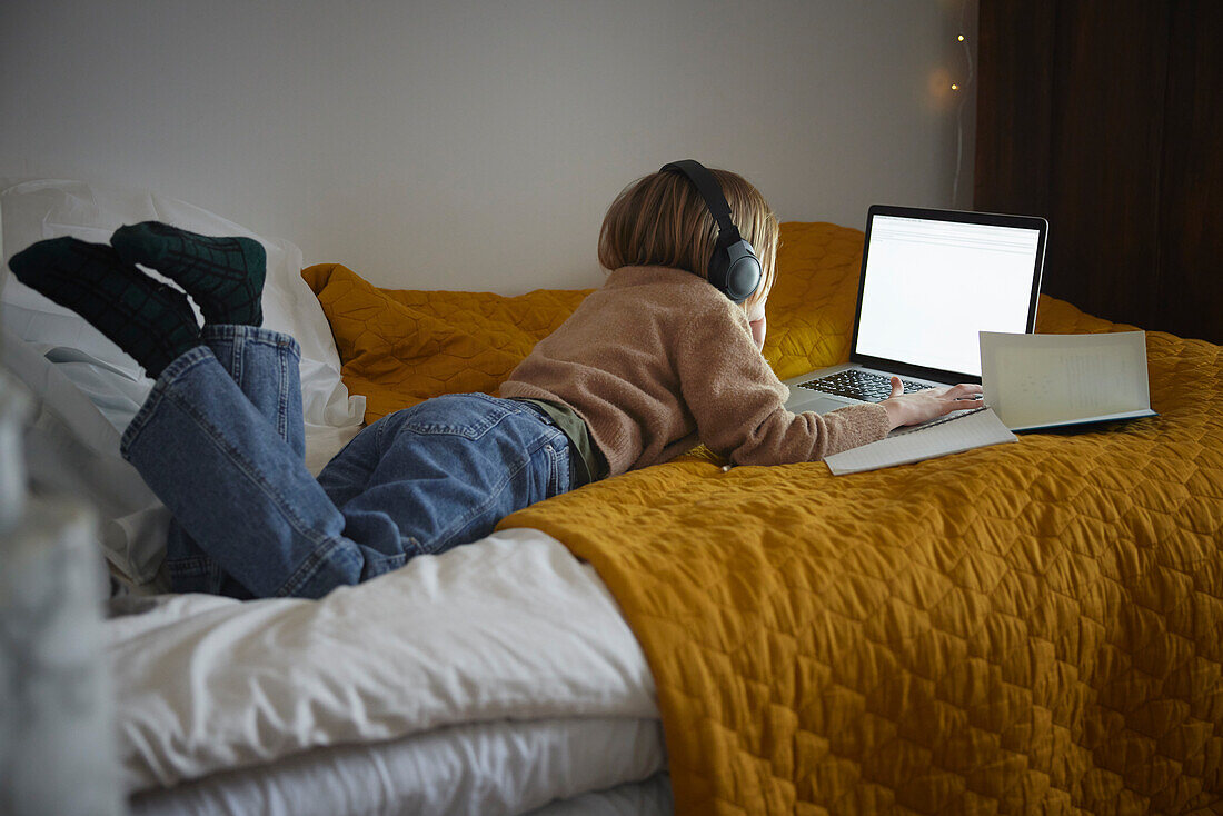 Girl using laptop in her bedroom