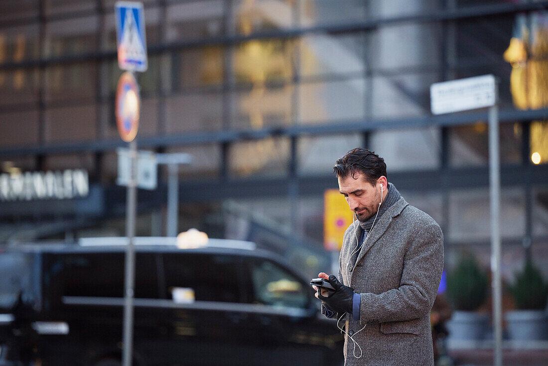 Businessman using phone outdoors in city