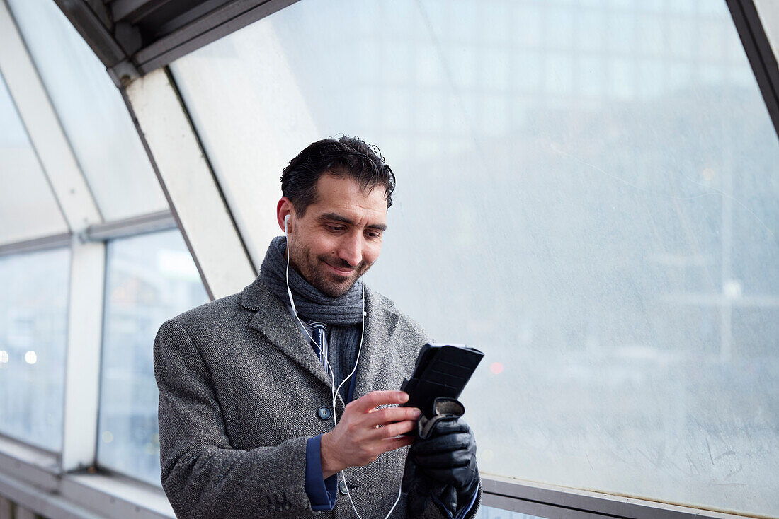 Businessman using phone outdoors in city