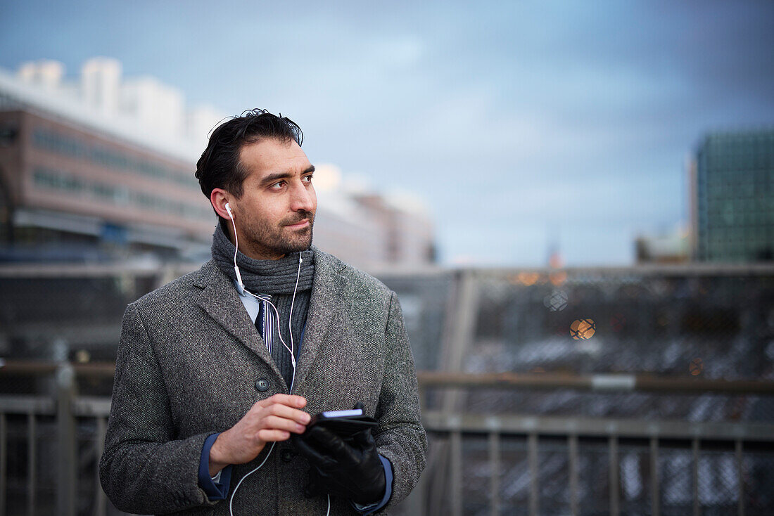 Businessman using phone outdoors in city